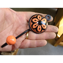 orange round ceramic coat hook with black flower