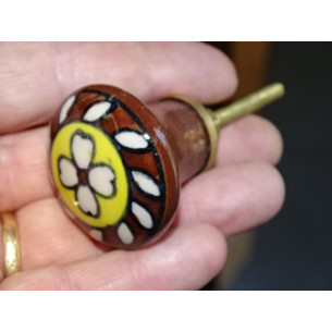 brown and yellow porcelain button with white flower