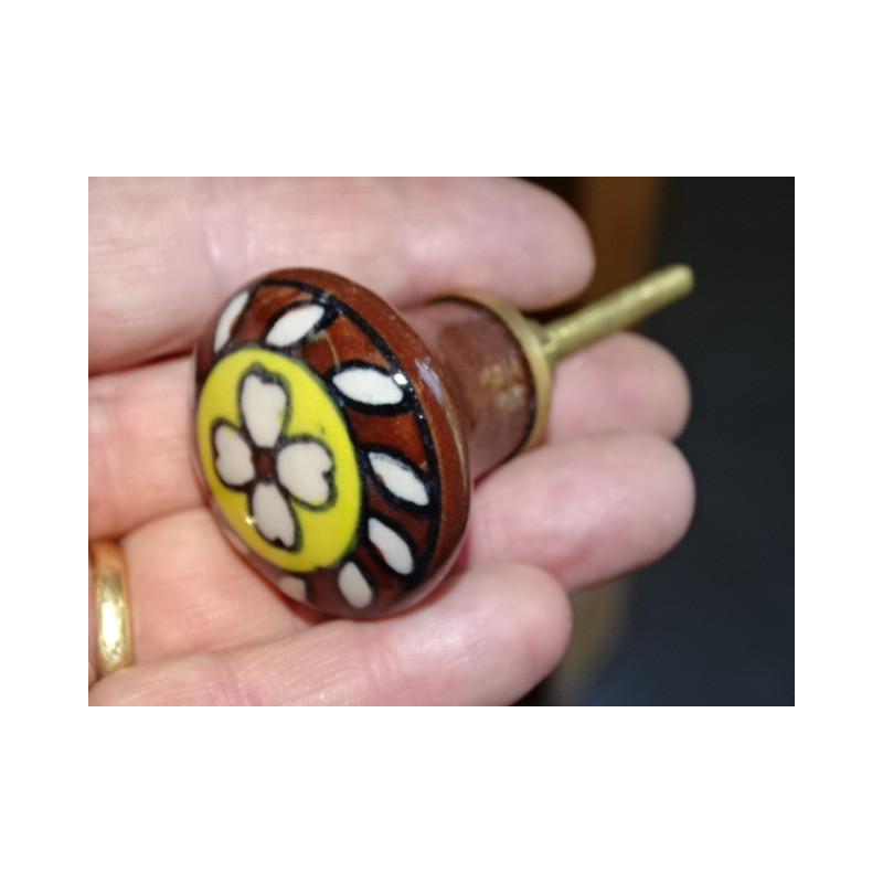 brown and yellow porcelain button with white flower